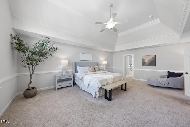 carpeted bedroom featuring a tray ceiling, baseboards, ornamental molding, and a ceiling fan