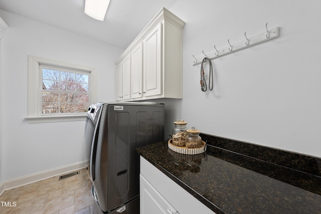 laundry area featuring visible vents, cabinet space, baseboards, and washing machine and clothes dryer