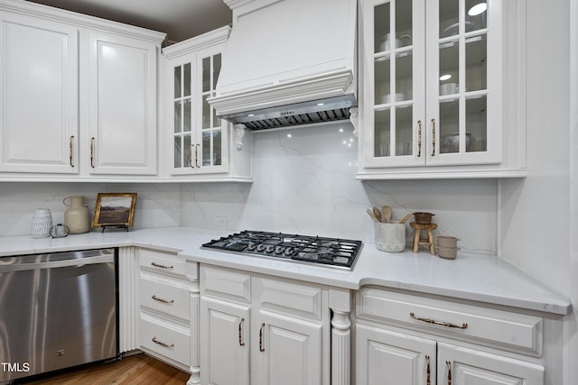 kitchen featuring white cabinets, glass insert cabinets, premium range hood, and stainless steel appliances