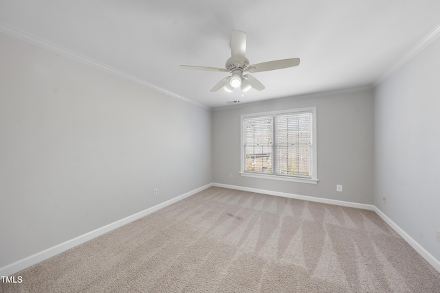 spare room featuring baseboards, a ceiling fan, light carpet, and crown molding