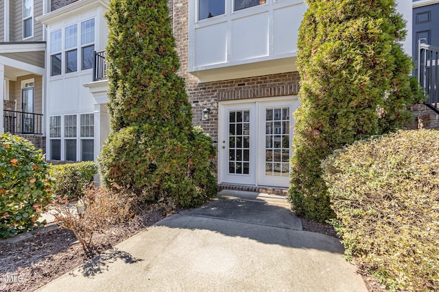 entrance to property featuring french doors and brick siding