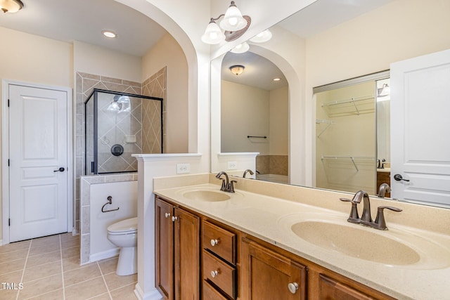 full bathroom with toilet, a stall shower, a sink, and tile patterned floors