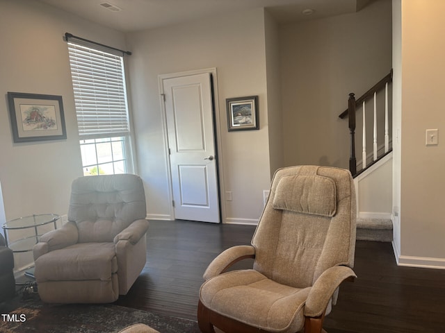 living area with dark wood-type flooring, stairway, visible vents, and baseboards