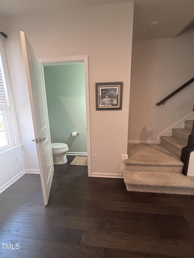 bathroom with toilet, baseboards, and wood finished floors