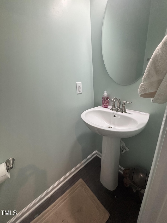 bathroom with baseboards and wood finished floors