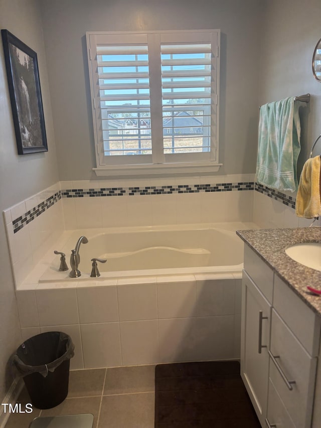 full bathroom with a garden tub, vanity, and tile patterned floors