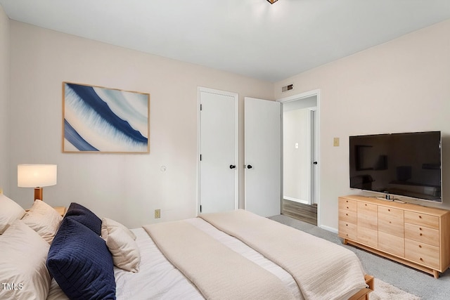 carpeted bedroom with visible vents and baseboards