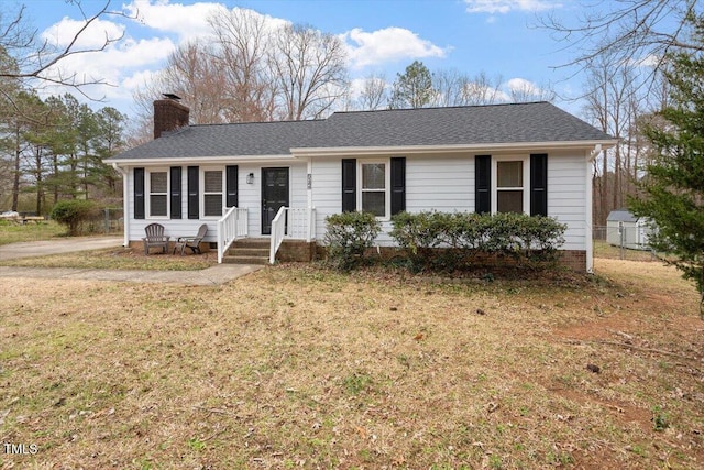 ranch-style home featuring a shingled roof, a front lawn, fence, and a chimney