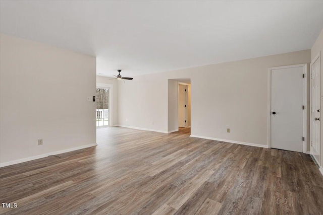 spare room with a ceiling fan, baseboards, and wood finished floors