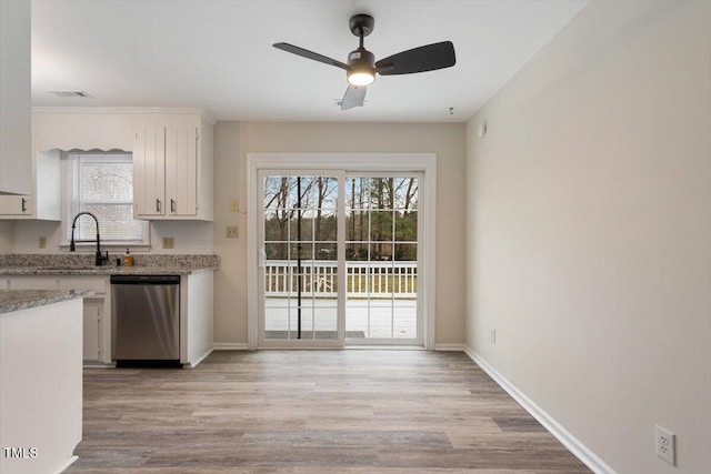 kitchen with a sink, visible vents, light wood-style floors, and stainless steel dishwasher