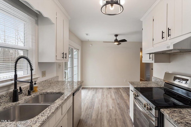 kitchen with light wood-style flooring, a sink, under cabinet range hood, stainless steel appliances, and ceiling fan