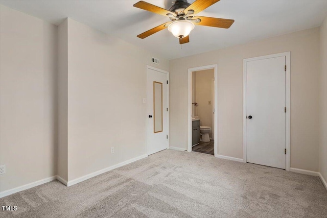 unfurnished bedroom featuring visible vents, baseboards, carpet floors, ceiling fan, and ensuite bathroom