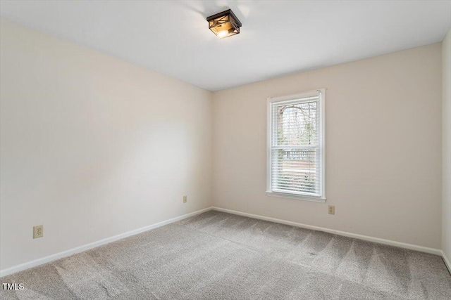 spare room featuring baseboards and carpet floors