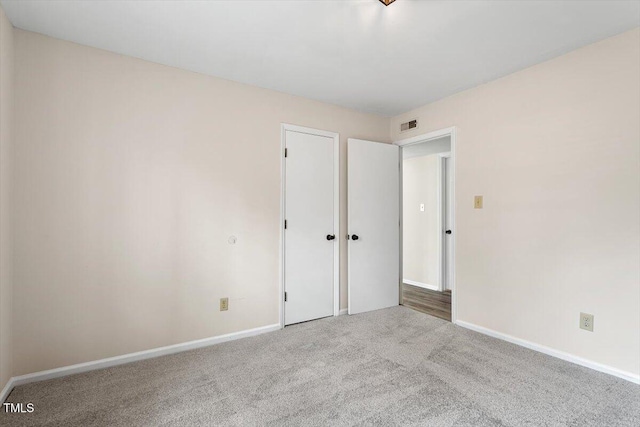 unfurnished bedroom featuring visible vents, baseboards, a closet, and carpet flooring