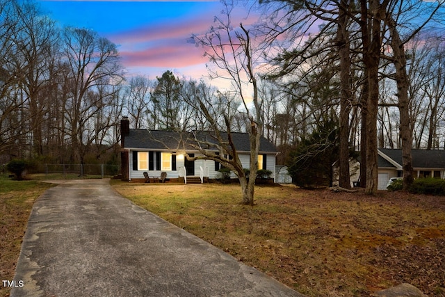 single story home with a lawn, fence, driveway, and a chimney