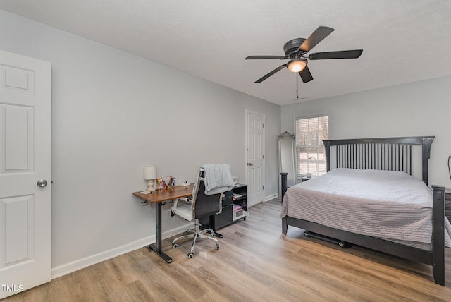 bedroom with a ceiling fan, light wood-type flooring, and baseboards