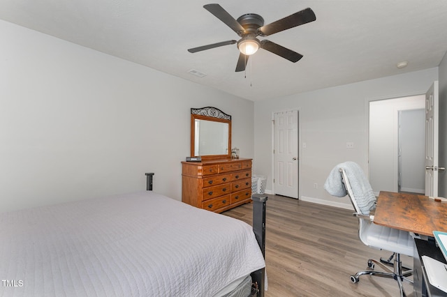 bedroom with ceiling fan, wood finished floors, visible vents, and baseboards