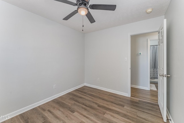 spare room with ceiling fan, baseboards, and wood finished floors