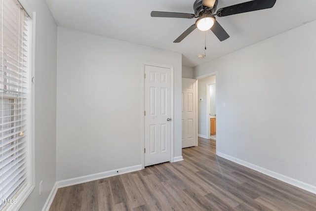 unfurnished bedroom with ceiling fan, baseboards, and wood finished floors