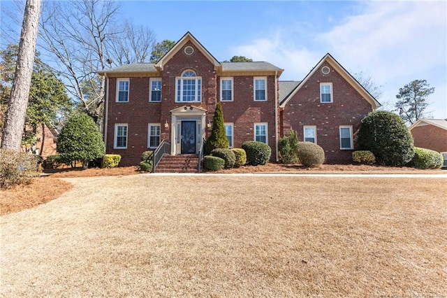 colonial inspired home featuring brick siding