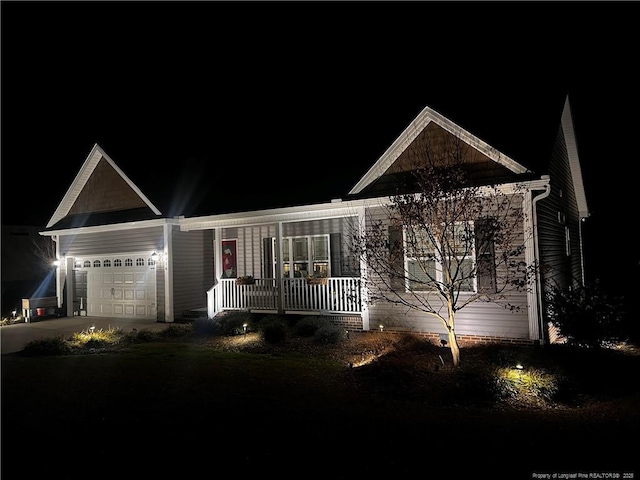 view of front facade with an attached garage, driveway, and a porch