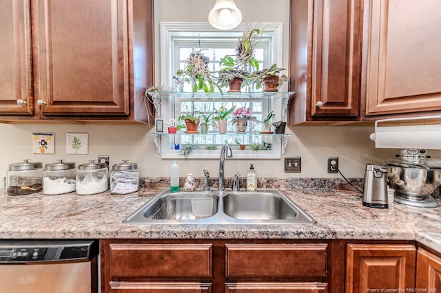 kitchen featuring dishwasher, light countertops, a sink, and brown cabinetry