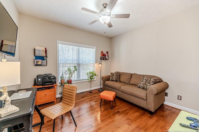 home office with baseboards, visible vents, a ceiling fan, and wood finished floors