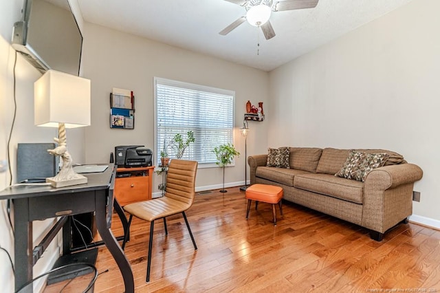 office area featuring light wood-style floors, baseboards, and a ceiling fan