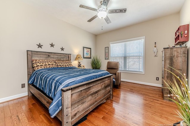 bedroom with hardwood / wood-style flooring, ceiling fan, and baseboards