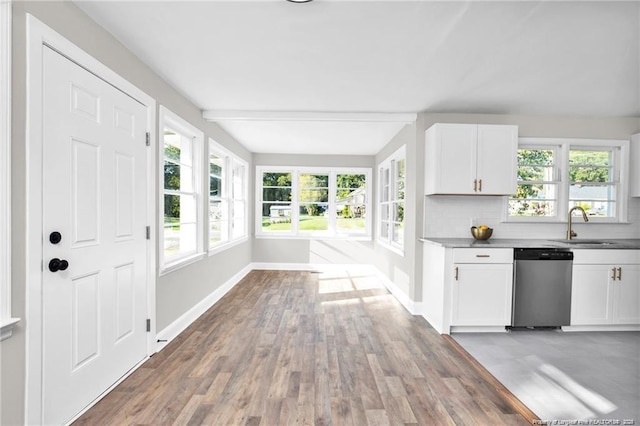 kitchen featuring a sink, baseboards, white cabinets, backsplash, and dishwasher