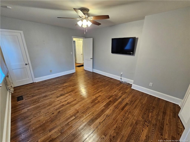 unfurnished bedroom featuring a ceiling fan, visible vents, baseboards, and wood finished floors