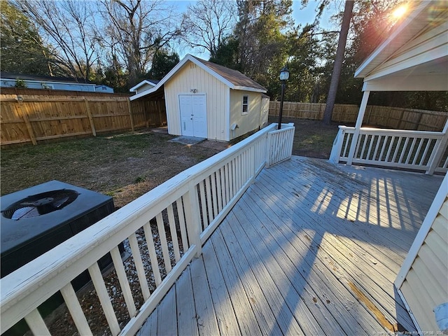 wooden deck with a fenced backyard and an outdoor structure