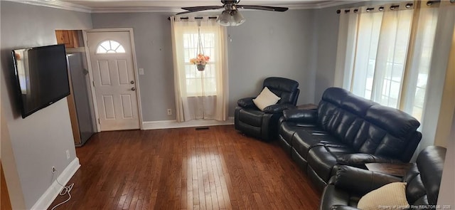 interior space featuring dark wood finished floors, a ceiling fan, baseboards, and ornamental molding