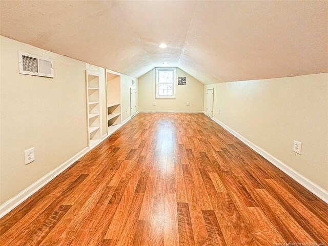 1003 Anarine Rd, Fayetteville, NC 28303 - additional living space with light wood finished floors, lofted ceiling, baseboards, and built in shelves
