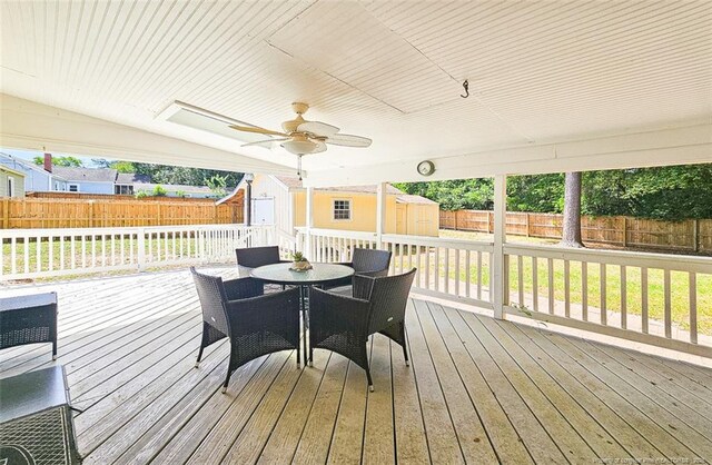1003 Anarine Rd, Fayetteville, NC 28303 - wooden terrace featuring a storage shed, outdoor dining area, an outdoor structure, and a fenced backyard
