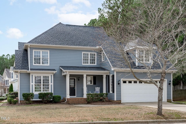 view of front of home featuring a front yard, a porch, a shingled roof, concrete driveway, and a garage