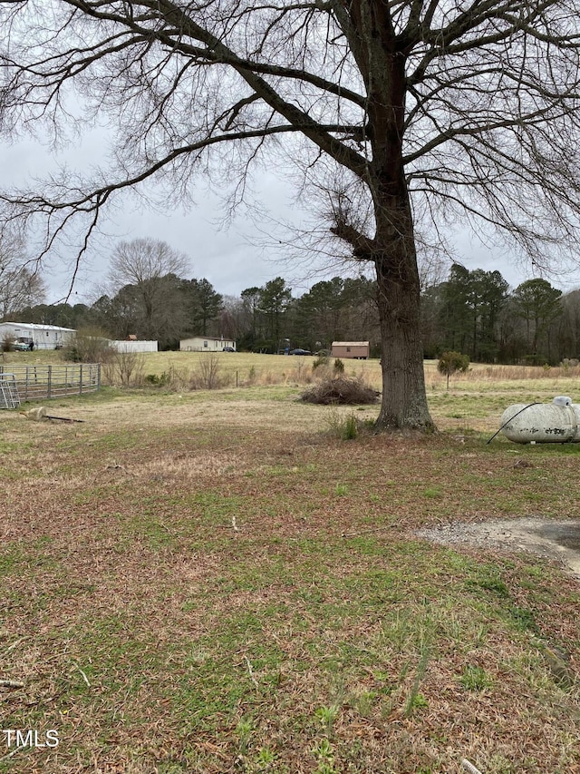 view of yard with a rural view and fence