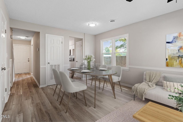 dining room featuring visible vents, baseboards, and wood finished floors