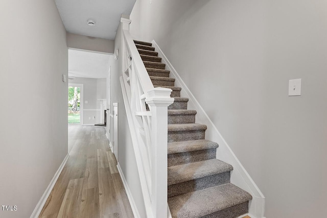 stairway with baseboards and wood finished floors