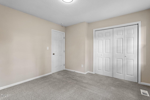 unfurnished bedroom with carpet floors, a closet, visible vents, and baseboards