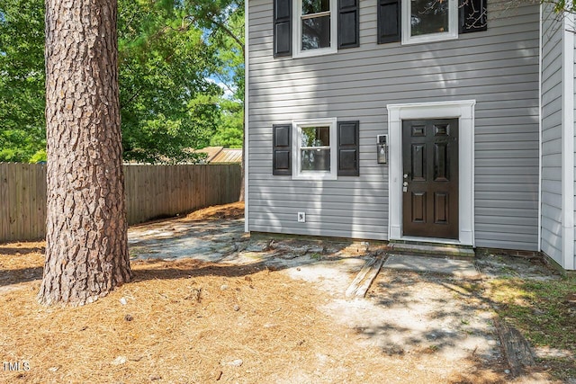 view of exterior entry featuring fence