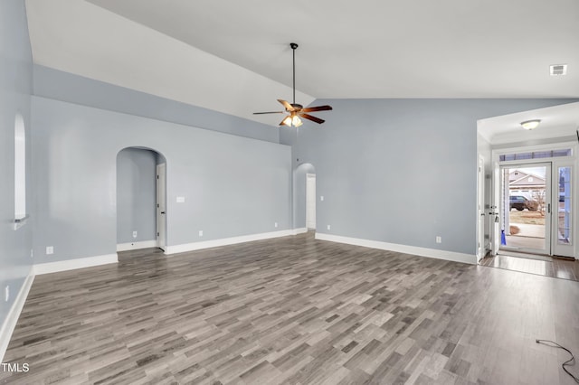 unfurnished living room featuring vaulted ceiling, wood finished floors, arched walkways, and ceiling fan