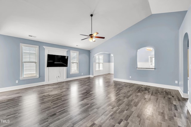 unfurnished living room featuring visible vents, ceiling fan, vaulted ceiling, wood finished floors, and arched walkways