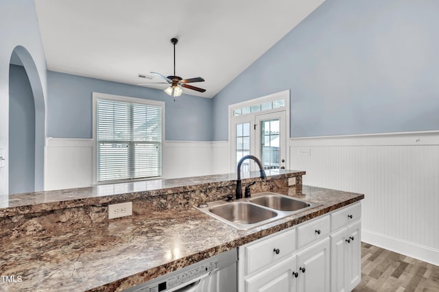 kitchen featuring white cabinetry, a healthy amount of sunlight, wainscoting, and a sink