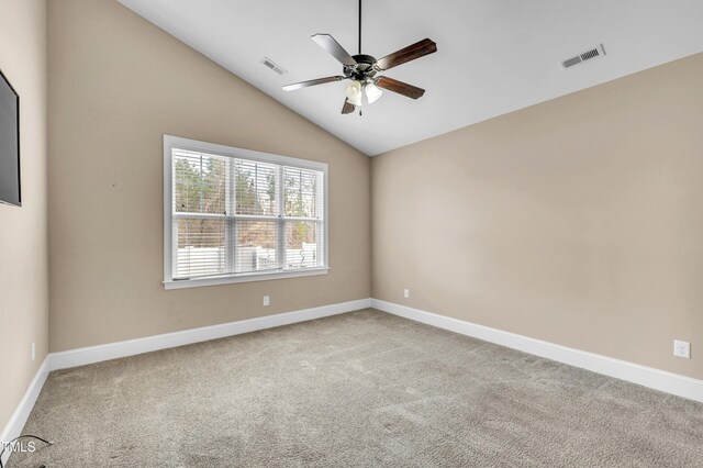 carpeted empty room with visible vents, lofted ceiling, baseboards, and ceiling fan