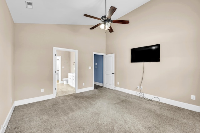 unfurnished bedroom featuring visible vents, baseboards, light colored carpet, and high vaulted ceiling