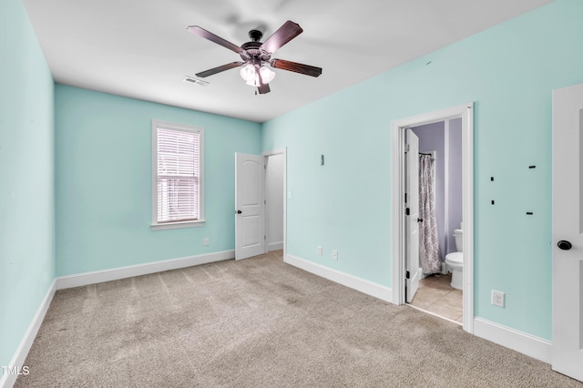 unfurnished bedroom featuring visible vents, baseboards, ensuite bath, and carpet flooring