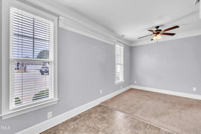 carpeted spare room featuring visible vents, ceiling fan, baseboards, and ornamental molding