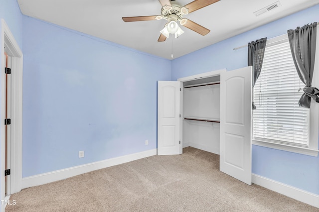 unfurnished bedroom featuring carpet, visible vents, a closet, and baseboards