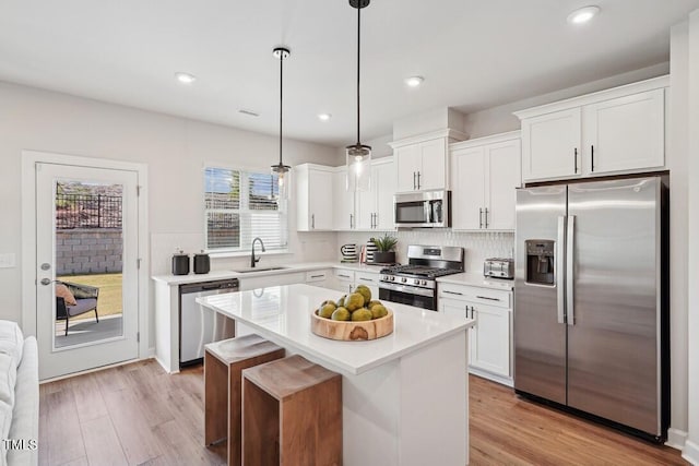 kitchen featuring white cabinetry, appliances with stainless steel finishes, light countertops, and a sink